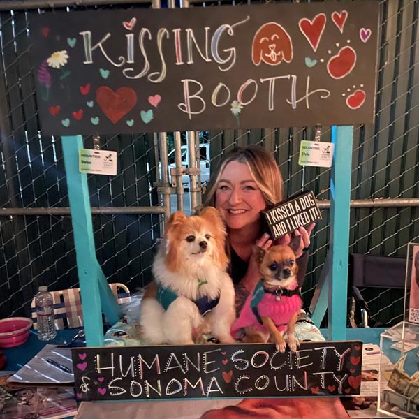 HSSC Executive Director Lindsay McCall at the Juncture Taproom with the kissing booth pups