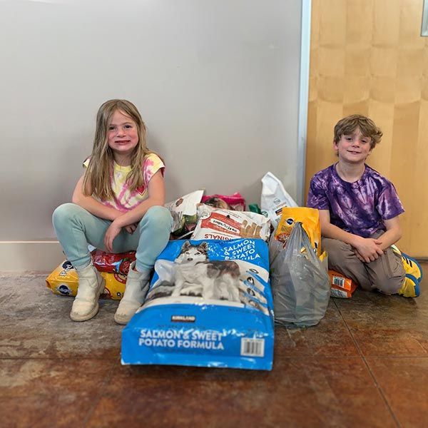 Thea and Wyatt with their pet food and supply donation
